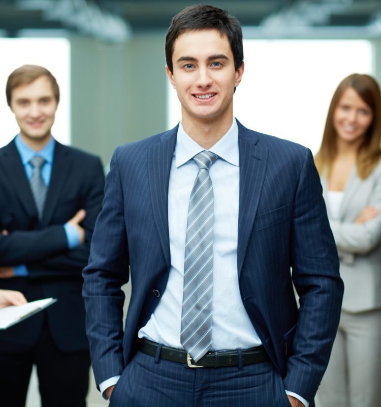 Group of friendly businesspeople with male leader in front